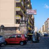Circondato da cassonetti dell�immondizia e insegne...